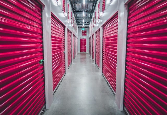 Hallway in a  storage facility with pink doors on both sides
